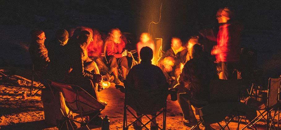 night image of people sitting around campfire